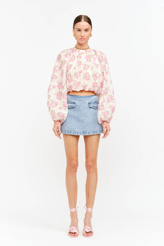 Model wearing a soft pink floral long sleeve blouse with a billowy silhouette, gathered neckline, and elasticized cuffs