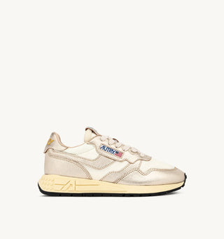 Autry Reelwind women’s sneakers in gold tone nylon with metallic leather detailing, retro runner silhouette with cushioned sole and branded tongue.