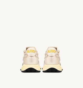 Autry Reelwind women’s sneakers in gold tone nylon with metallic leather detailing, retro runner silhouette with cushioned sole and branded tongue.
