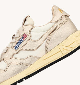 Autry Reelwind women’s sneakers in gold tone nylon with metallic leather detailing, retro runner silhouette with cushioned sole and branded tongue.