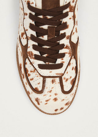 Sneaker with brown speckles on a white background