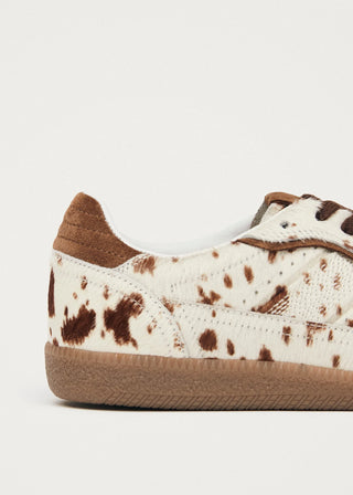 Sneaker with brown and white spotted pattern on a light gray background