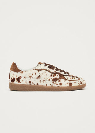 Sneaker with brown speckles on a light gray background