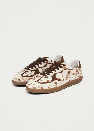 Pair of brown and white sneakers on a light gray background