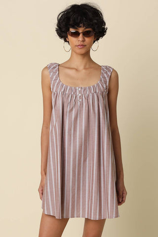 Woman wearing a striped dress on a beige background
