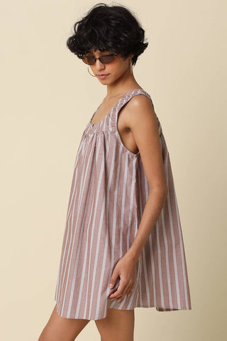 Woman wearing a striped dress against a beige background