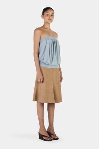Woman wearing a strapless top and skirt on a white background