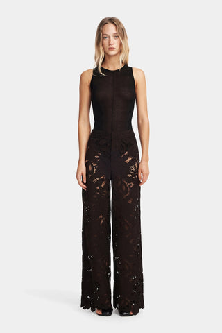 Woman wearing a black lace jumpsuit on a white background