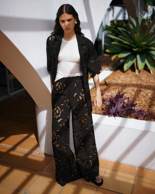 Woman wearing a black outfit with floral patterns in an outdoor setting
