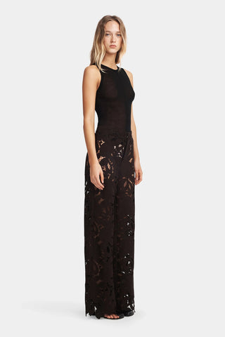 Woman wearing a black lace jumpsuit on a white background