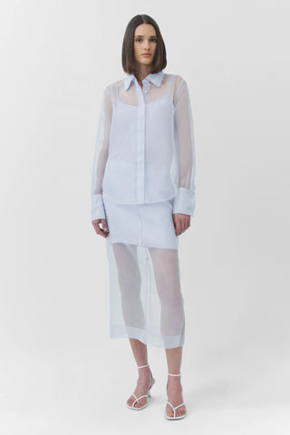 Woman wearing a light blue sheer outfit on a white background