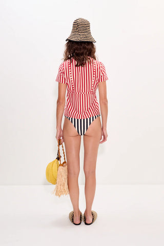 Woman wearing a red and white striped swimsuit with a yellow bag on a white background