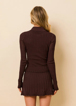 Woman wearing a brown ribbed long-sleeve top and skirt set against a beige background