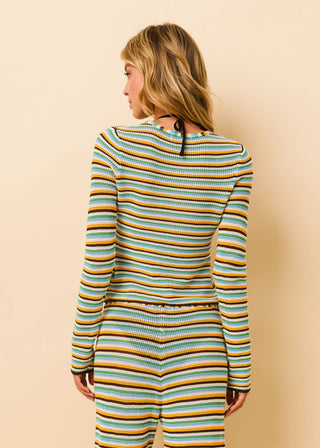 Woman wearing a striped onesie against a beige background