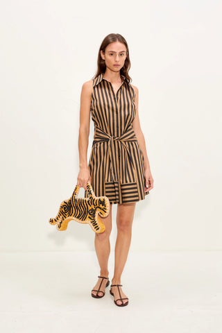 Woman wearing a striped dress holding a tiger-shaped bag on a white background