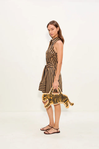 Woman wearing a zebra-striped dress holding a tiger-striped bag on a white background