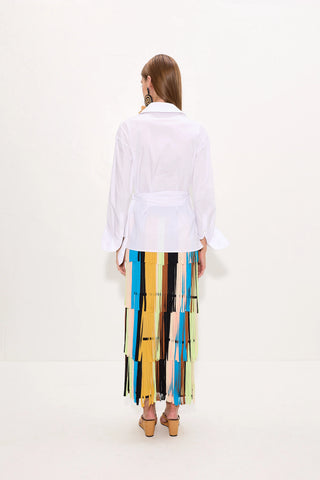 Woman wearing a white shirt and colorful striped skirt on a white background