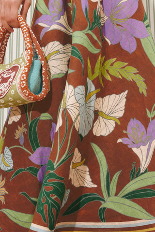 Close-up of a person wearing a floral dress with a colorful handbag.