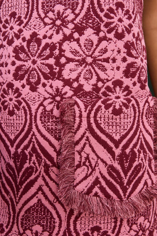 Close-up of a pink and purple patterned fabric with frayed edges.