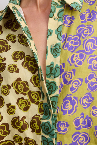 Close-up of a patterned fabric with floral designs in green, purple, and brown.