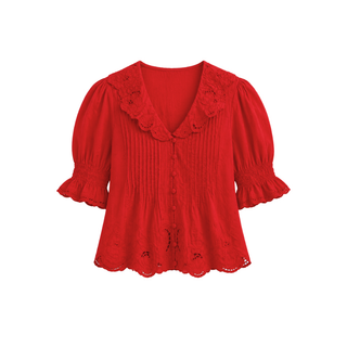 A bright red short-sleeve blouse with a ruffled eyelet lace V-neckline, smocked front, and ruffled cuffs, shown against a plain white background.