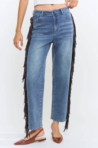 Blue jeans with fringe details on a white background