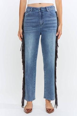 Blue jeans with fringe details on a white background