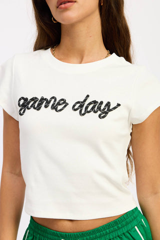 White crop top with 'game day' text worn by a person on a white background