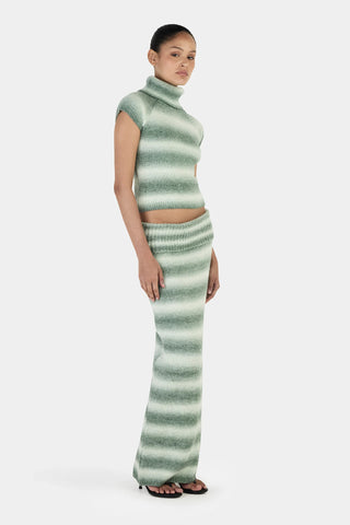 Woman wearing a green and white striped outfit on a white background