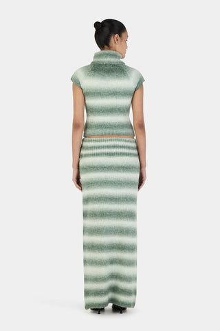 Woman wearing a green and white striped dress on a white background