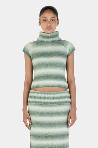 Woman wearing a green and white striped outfit on a light gray background