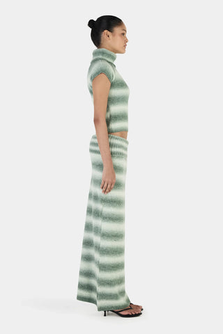 Woman wearing a green and white striped dress on a white background