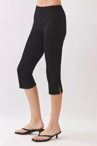 Person wearing black capri pants on a white background