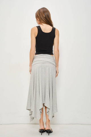 A woman shown from the back wearing a black sleeveless top and a light gray high-low wrap skirt, standing against a plain white studio background.