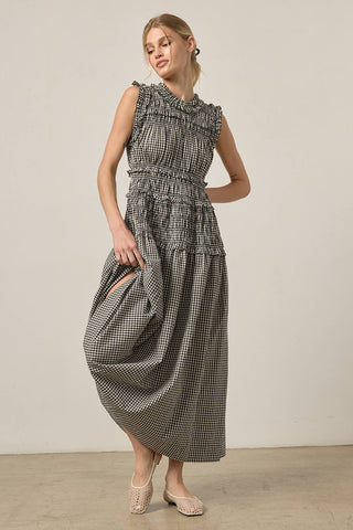 Woman wearing a black and white checkered dress against a plain background