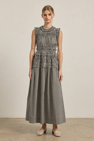 Woman wearing a checkered dress against a plain background