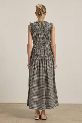 Woman wearing a black and white checkered dress against a plain background