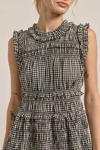 Black and white checkered dress with ruffled details on a plain background
