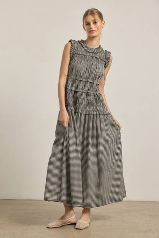 Woman wearing a black and white checkered dress against a plain background
