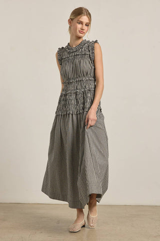 Woman wearing a checkered dress against a plain background