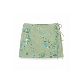 A sage green wrap-style mini skirt with a textured crocodile pattern, decorated with blue and white sequins, and featuring a side tie closure.