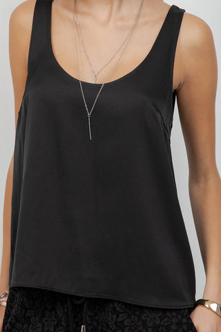 Black tank top worn by a person on a plain background