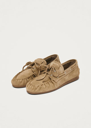Beige suede leather loafers with moccasin stitching and lace up detail on a clean background