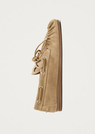 Beige suede leather loafers with moccasin stitching and lace up detail on a clean background