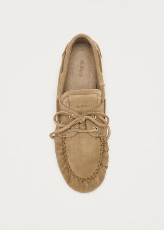 Tan suede loafer shoe on a light beige background